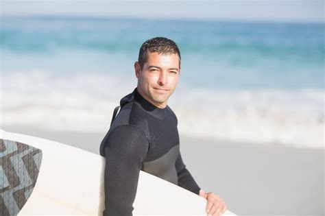 Homem Segurando Prancha De Surf Na Praia Foto Premium