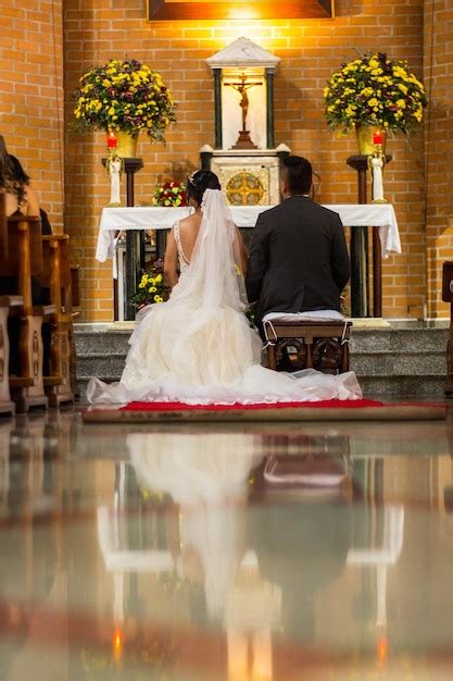 A Noiva E O Noivo Sentam Se Em Frente A Um Altar Uma Cruz No Altar