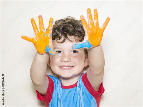 Niño mostrando sus manos pintadas Foto Stok Adobe Stock