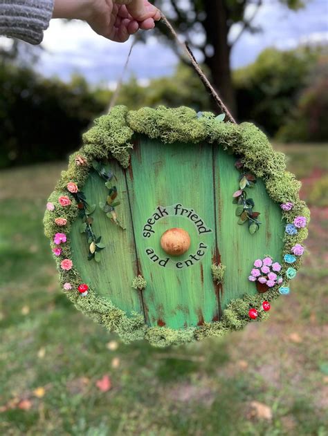 A Hand Holding A Green Door With Flowers On It And The Words Create A