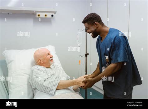 Trabajador De La Salud Sonriente Que Toma De La Mano Del Paciente