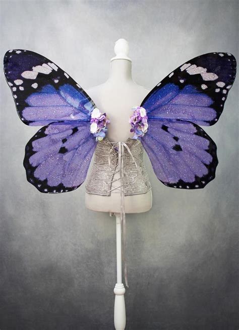 A White Mannequin With Purple And Blue Butterfly Wings On It S Head