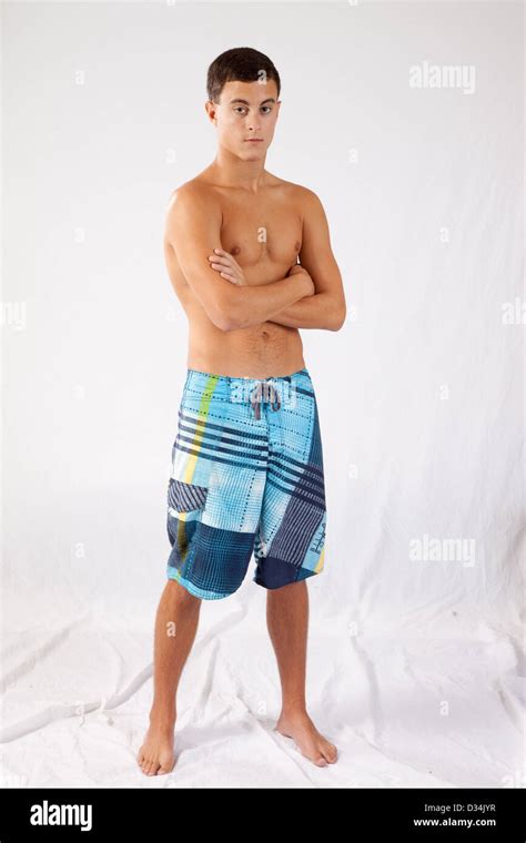 Teenage Boy Standing Shirtless And In Swim Trunks With His Arms Stock