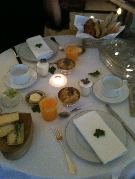 A White Table Topped With Plates And Cups Filled With Food Next To A