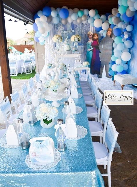 A Table Set Up With Blue And White Decorations For A Frozen Princess