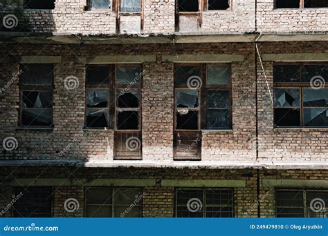 La Pared De Un Viejo Edificio De Ladrillo Abandonado Con Ventanas Rotas