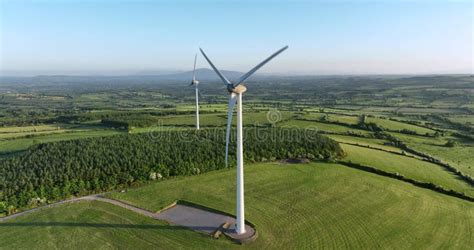 Large Wind Turbine With Blades On Green Field Aerial View Of Green