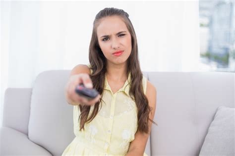 Premium Photo Frowning Pretty Brunette Holding Remote