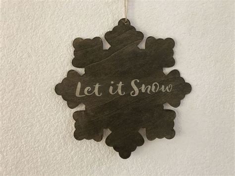 A Wooden Sign That Says Let It Snow