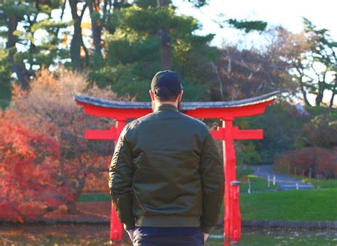 Premium Photo Rear View Of Man Standing Against Torii Gate In Park