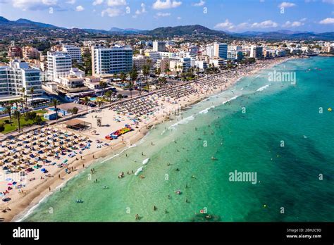 Spain, Balearic Islands, Cala Bona, Aerial view of resort town and crowded beach in summer Stock ...