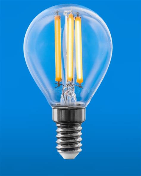 Energy Efficient Led Filament Light Bulb Glowing Isolated On Blue