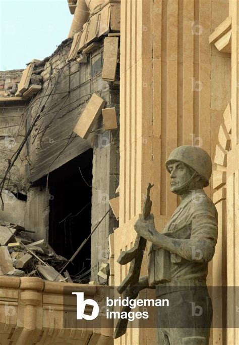 Image of STATUE OVERLOOKS DAMAGE TO SADDAM HUSSEIN'S PALACE IN TIKRIT, 2003-04-14