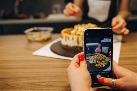 Jeune femme prenant des photos d un gâteau dans la cuisine Femme