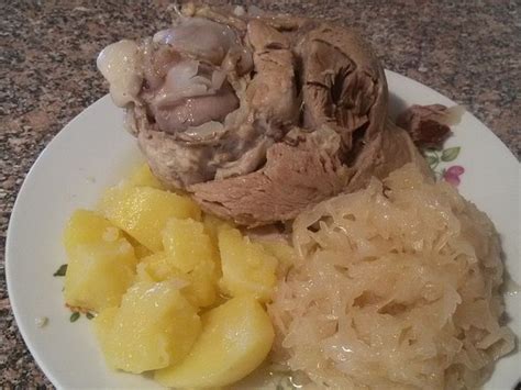 A White Plate Topped With Meat And Potatoes