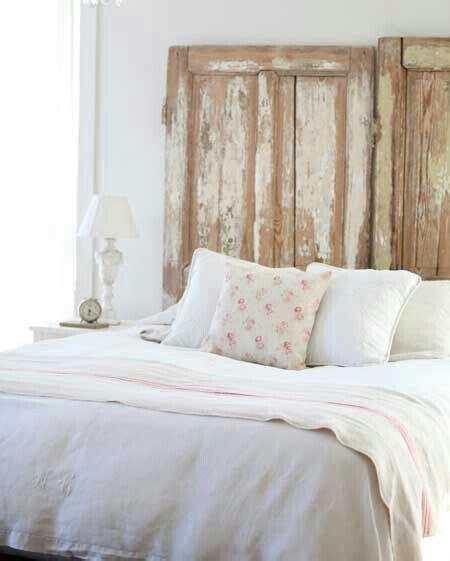 A Bed That Has Some Pillows On It And A Chandelier Hanging From The Ceiling