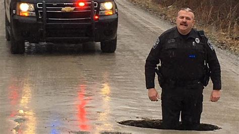 Michigan Pothole So Large Police Officer Stands Knee Deep Fox News