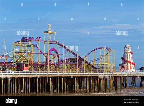 Clacton pier funfair with a roller coaster and helter skelter amongst ...