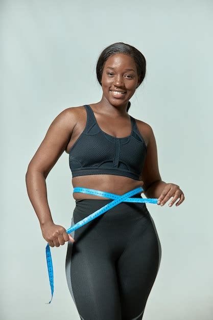 Premium Photo Smiling African American Girl Measuring Waist With Tape