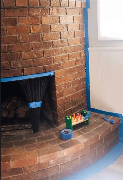 A Brick Fireplace In The Corner Of A Room With Blue Paint On The Walls