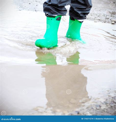 Child With Rain Boots Jumps Into A Puddle Stock Photo Image Of Boots