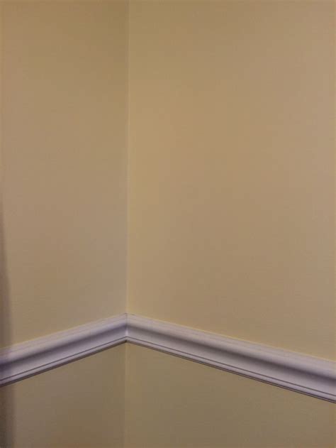 The Corner Of A Room With A White Toilet And Yellow Walls Painted In