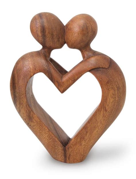 A Wooden Sculpture Of Two People Holding Each Other S Hands In The