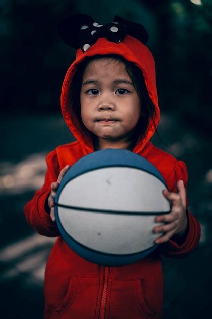 Premium Photo Portrait Of Cute Boy Holding Ball While Standing Outdoors