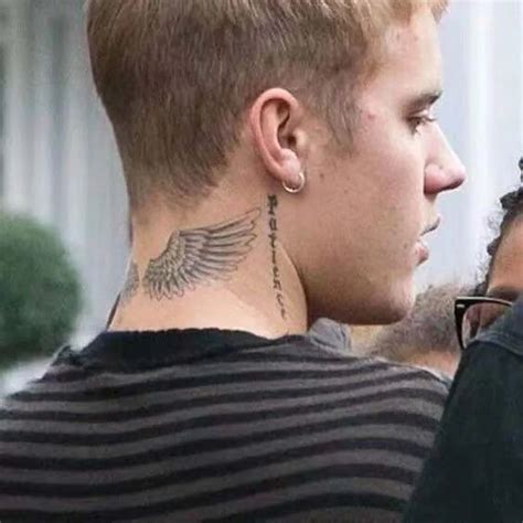 a man with a tattoo on his neck looking at another man's ear and nose