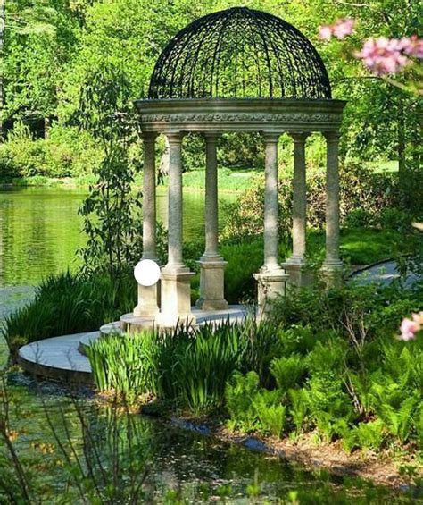 A Gazebo Sitting In The Middle Of A Park Next To A Lake And Trees