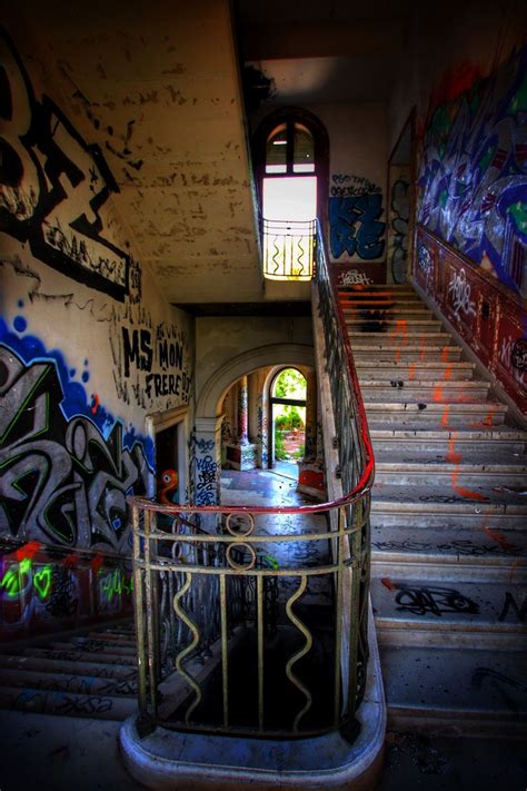 An Abandoned Building With Graffiti On The Walls And Stairs