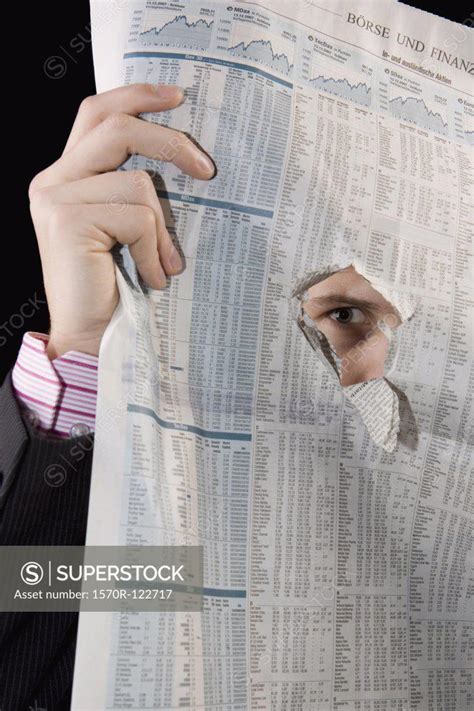 A Man Spying Through A Hole In A Newspaper Superstock