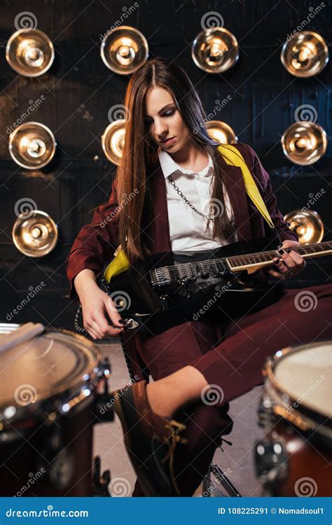 Female Rock Guitarist Sitting Behind The Drum Kit Stock Image Image