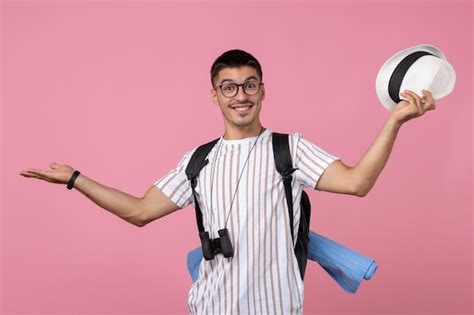 분홍색 배경에 흰색 티셔츠를 입은 젊은 남성 관광객 전면 보기 무료 사진