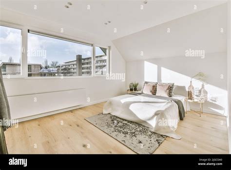 Attic Bedroom With Minimalist Interior Design And Panoramic Windows On