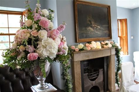 A Living Room Filled With Furniture And A Fire Place Covered In Flowers