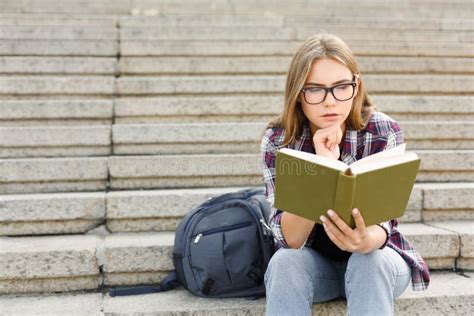 Livro De Leitura Da Jovem Mulher Em Escadas Da Universidade Imagem De