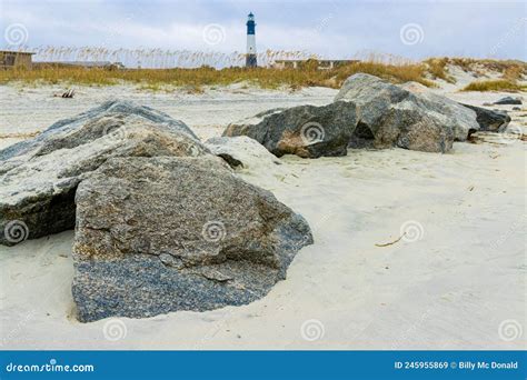 Exposed Jetty Boulders On North Beach With Historic Tybee Island Light