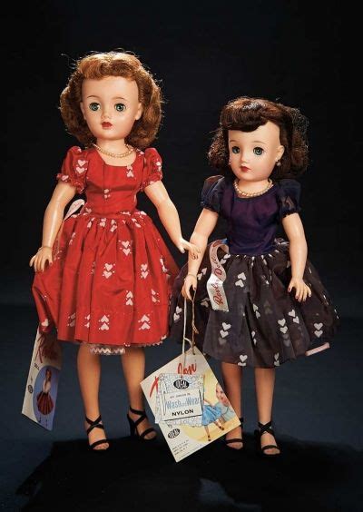 Two Dolls Are Standing Next To Each Other Holding Shopping Bags And