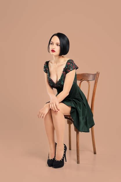 Premium Photo Gorgeous Lady In Short Dress Sitting On Chair In Studio