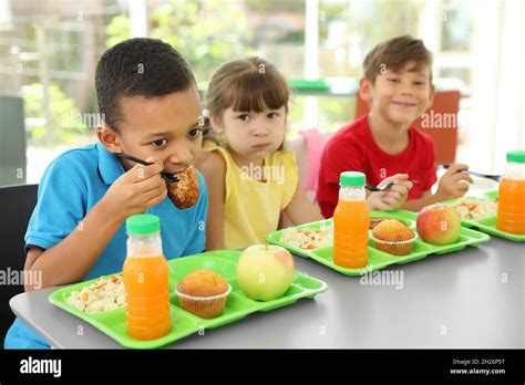 Children sitting at table and eating healthy food during break at school Stock Photo - Alamy