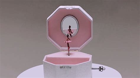 A Pink And White Box With A Ballerina Figure In The Mirror On Top Of It