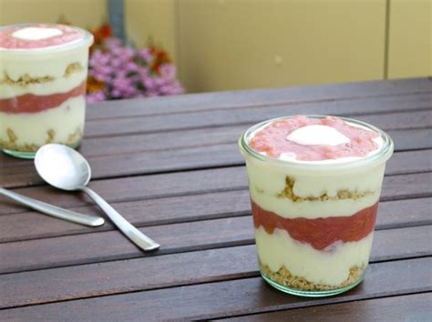 Two Desserts Sitting On Top Of A Wooden Table Next To A Spoon And Fork