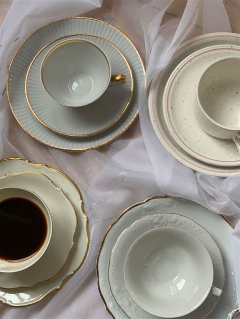 There Are Four Cups And Saucers Next To Each Other On The Tablecloths