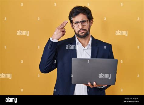 Hombre latino guapo que trabaja usando la computadora portátil que