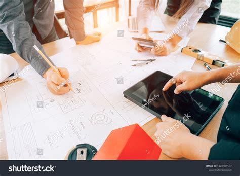 Engineers Pointing Building On Blueprint Drawing Stock Photo 1428908567