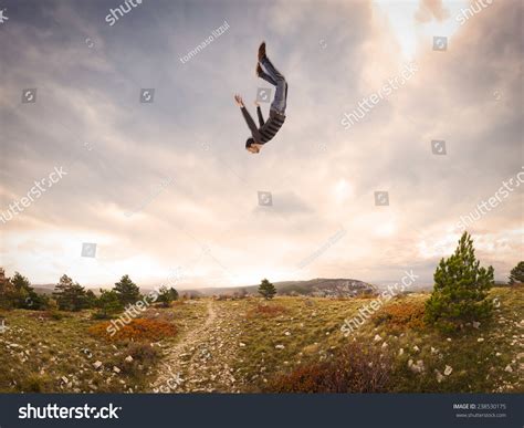 Man Falling Down From The Sky In Autumnal Landscape Stock Photo