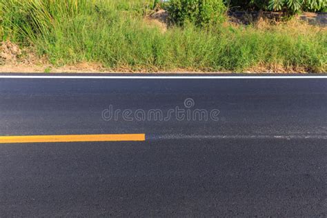 Linha Branca E Amarela Na Estrada Asfaltada Nova Imagem De Stock