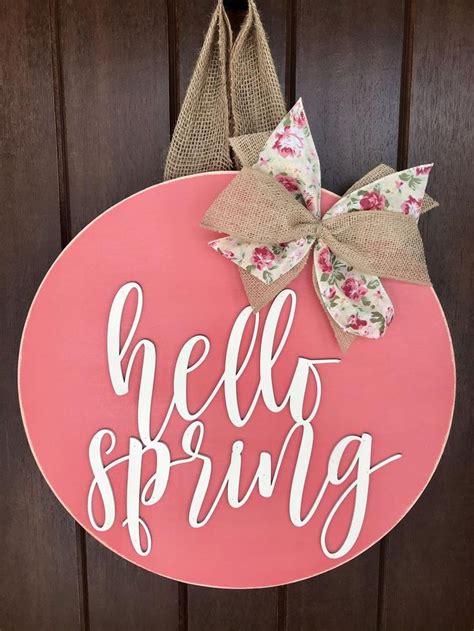 A Pink Door Hanger That Says Hello Spring With A Bow Hanging On The Front