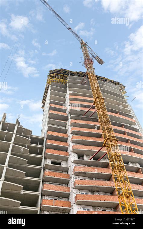 High Rise Building Under Construction With Yellow Tower Crane Stock